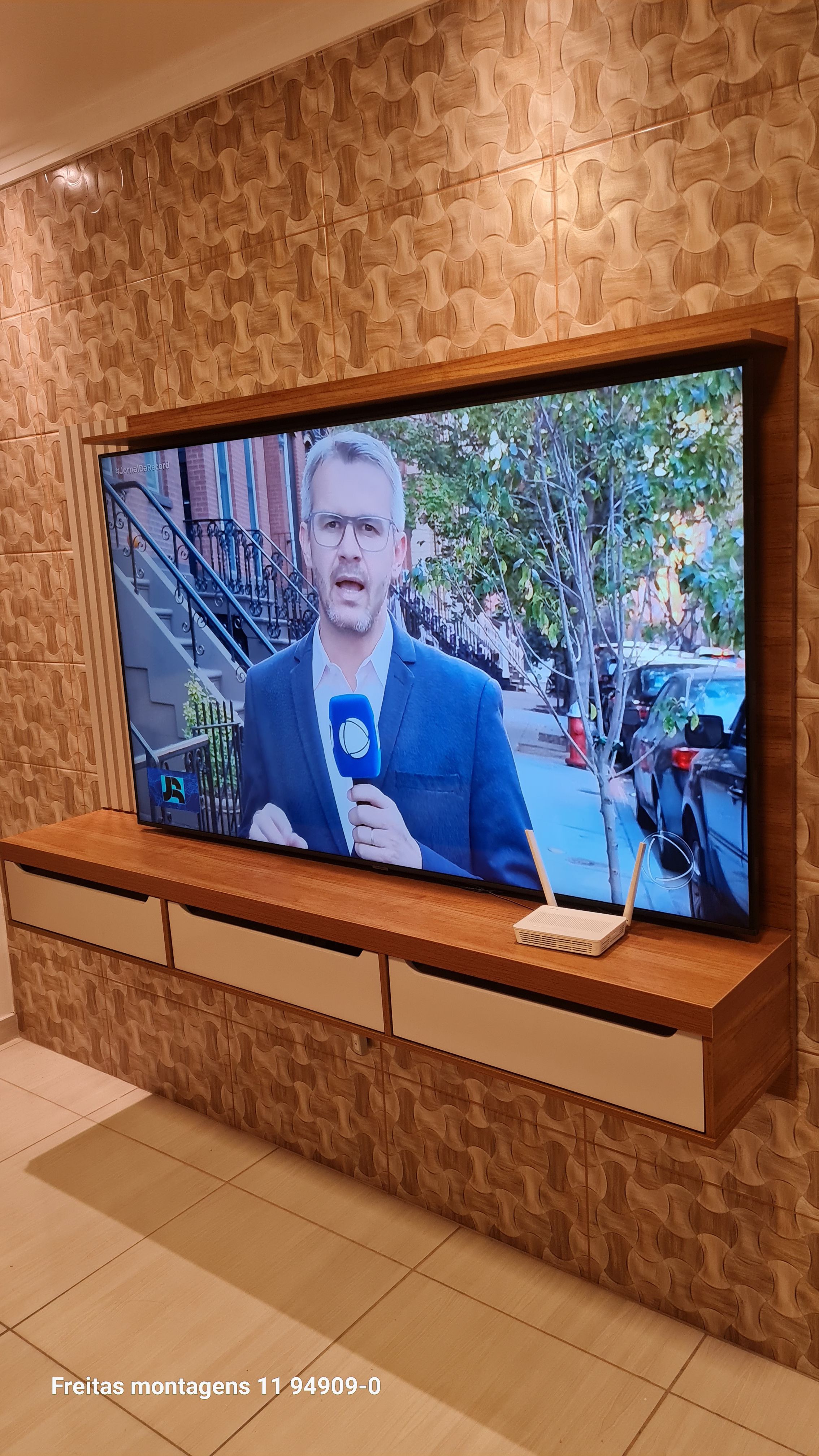 Montador fixando painel de TV na parede em residência localizada em Itaquera – montagem profissional de móveis na Zona Leste.